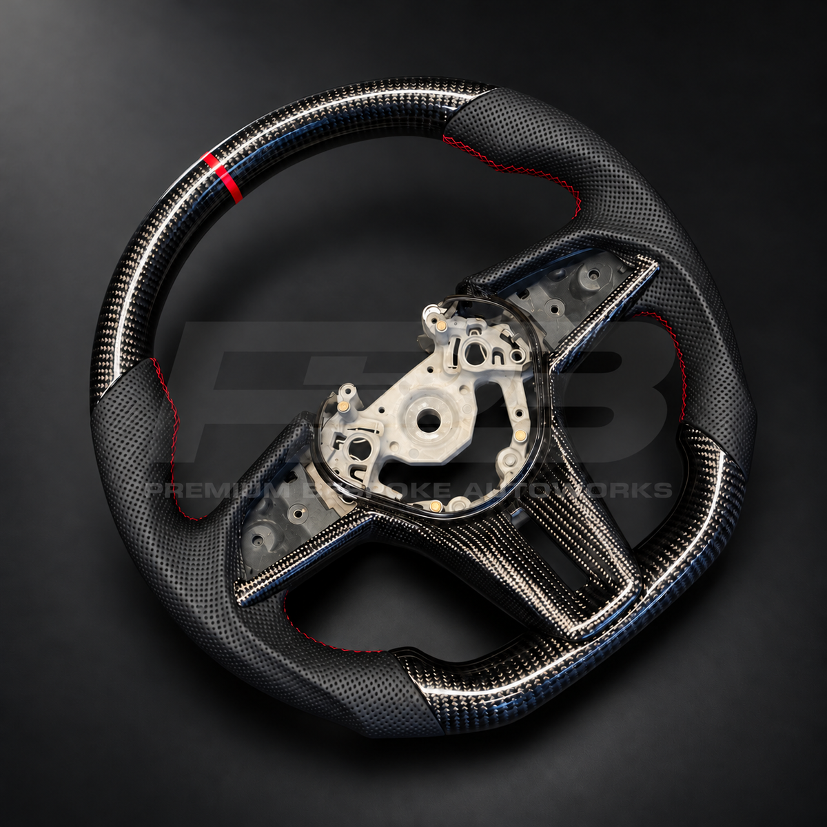 Nissan GT-R R35 EBA custom steering wheel, angled view showing the carbon fibre top section with red strip and perforated leather grip