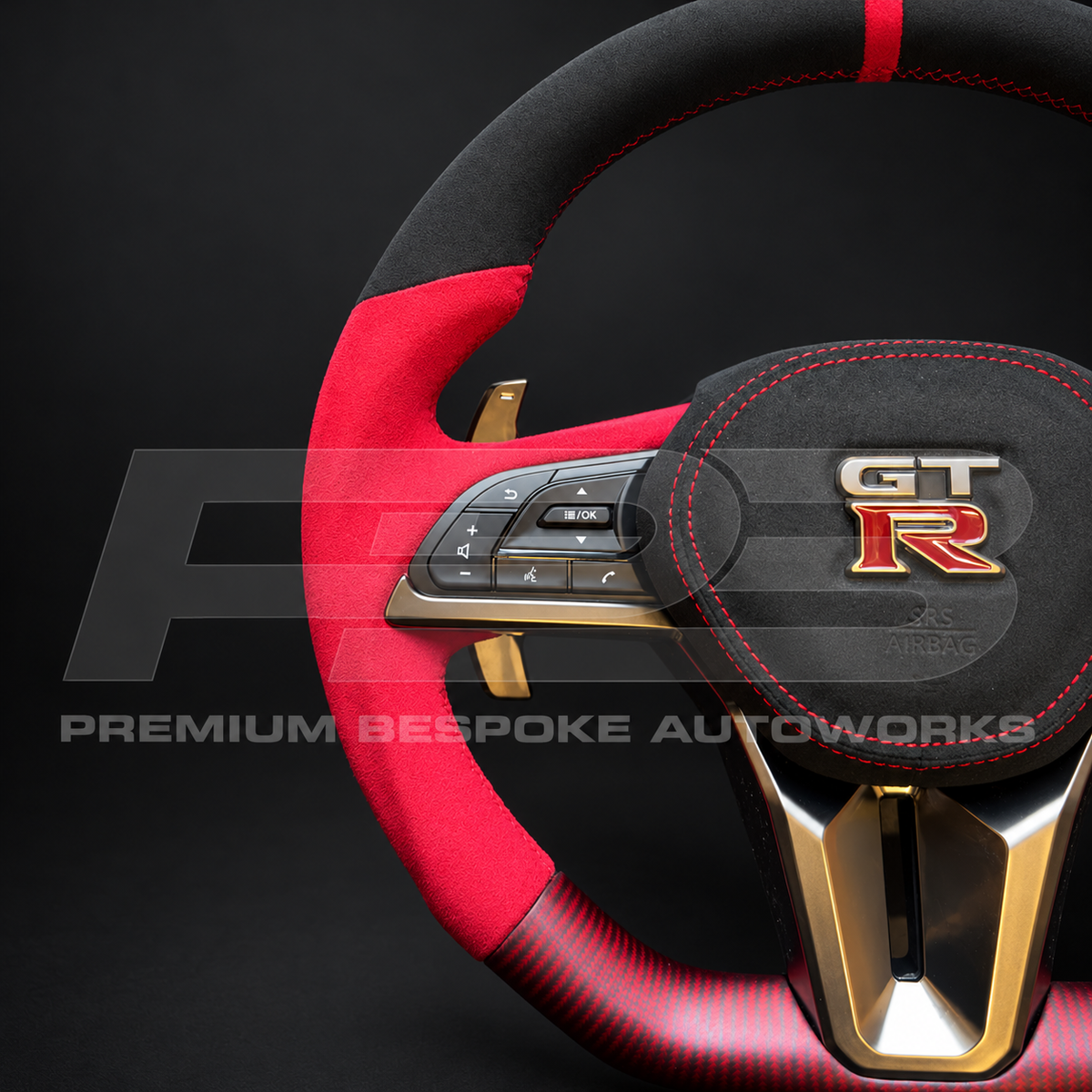 Close up of the black Alcantara airbag cover with red stitching and GT-R badge on a custom Nissan GT-R R35 EBA steering wheel