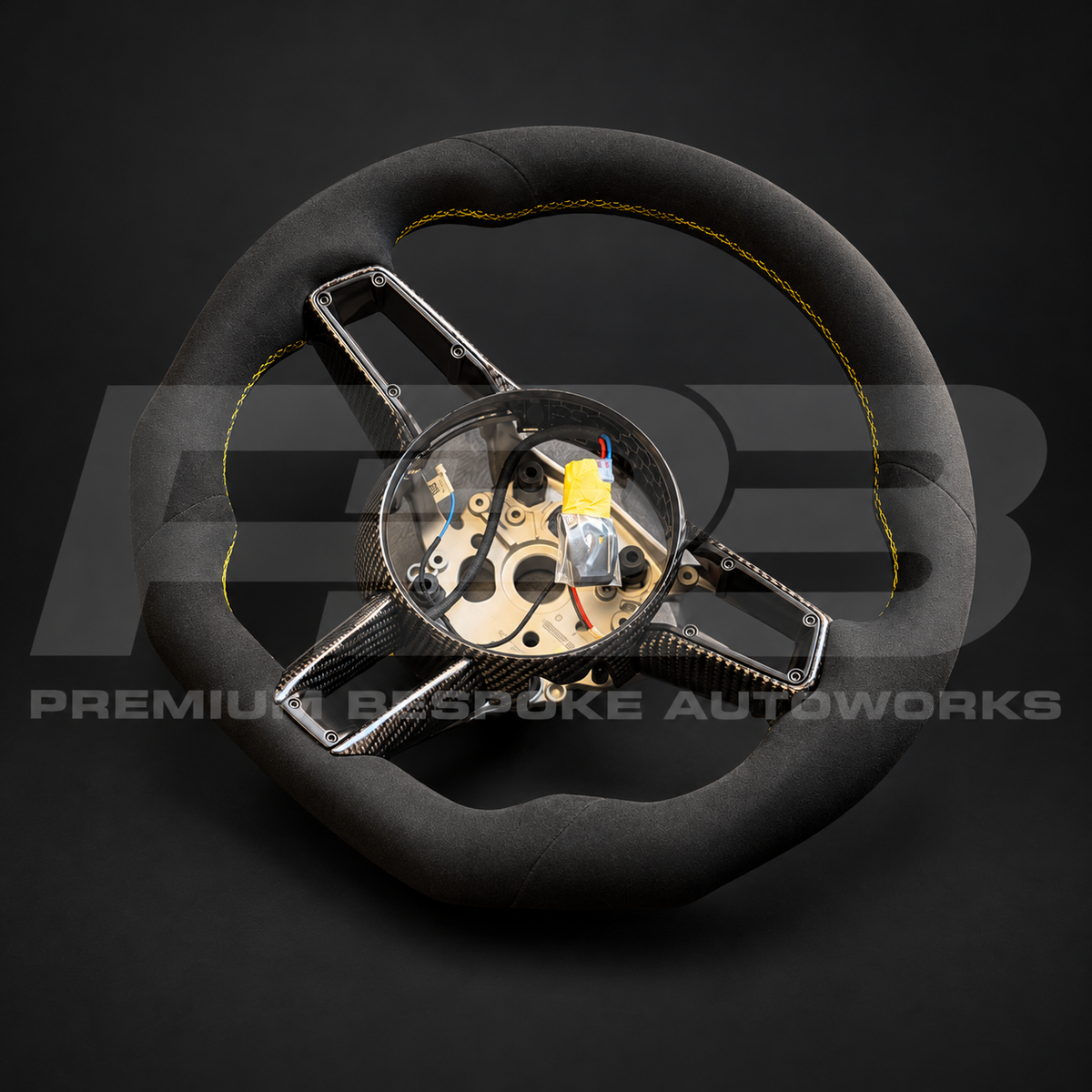 Porsche 911 992 custom steering wheel from above, flat bottom black Alcantara with yellow stitching and gloss carbon fibre trims