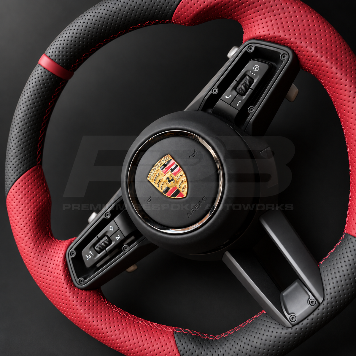 Porsche 911 992 custom steering wheel close up detail showing flat bottom, perforated black leather, red perforated grips, red stitching and red 12 o'clock marker