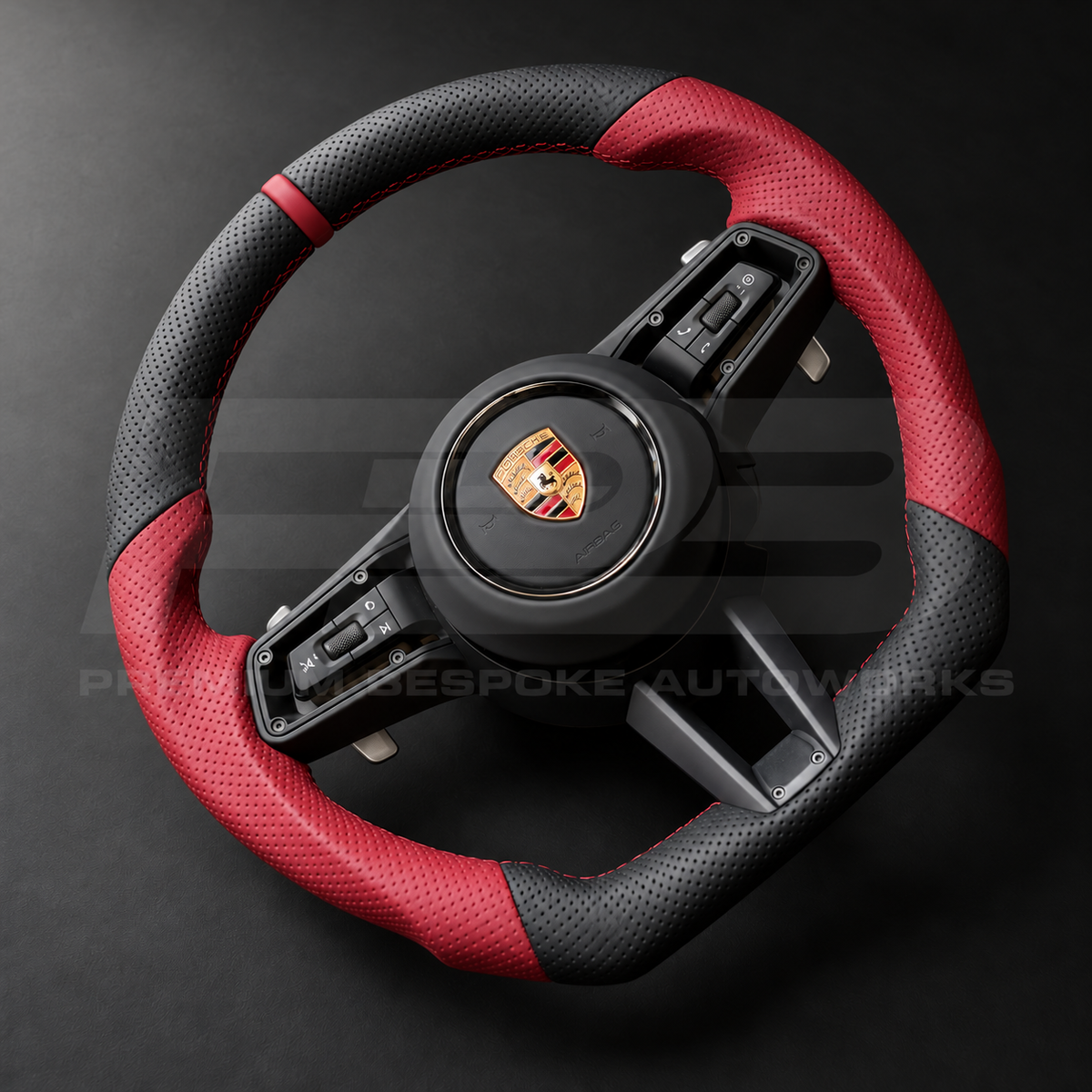 Porsche 911 992 custom steering wheel right angle showing flat bottom, perforated black leather, red perforated grips, red stitching and red 12 o'clock marker