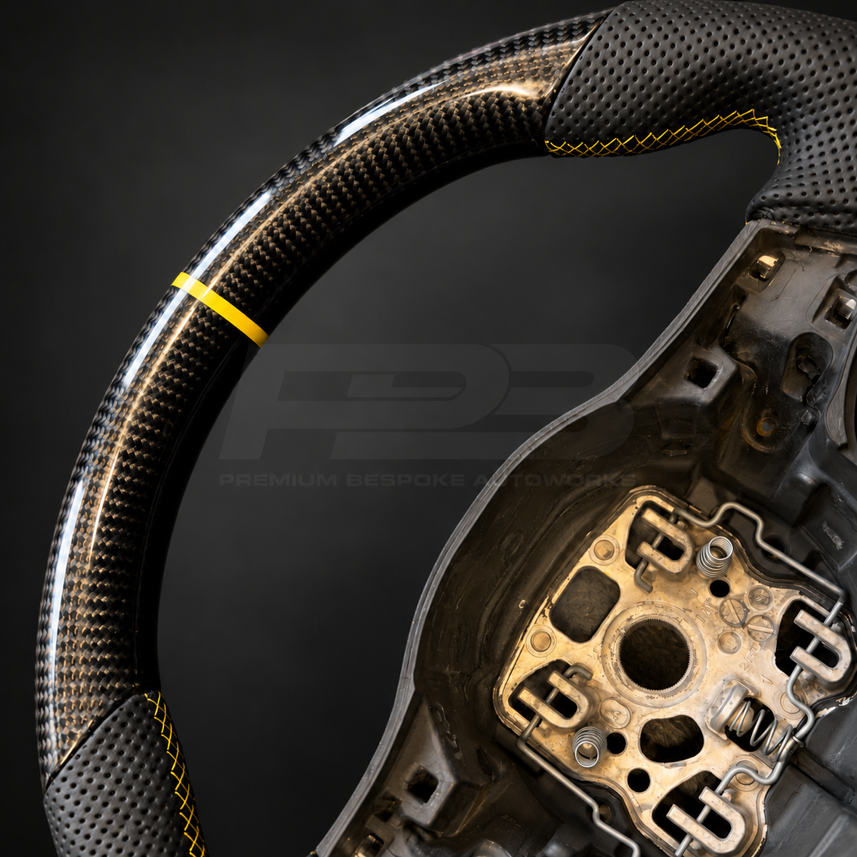 Porsche 911 997.2 custom steering wheel close up detail showing flat top and bottom, gloss carbon fibre, black perforated leather grips, yellow stitching and yellow marker