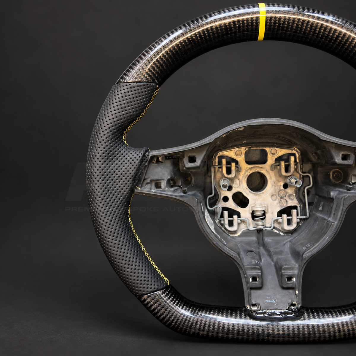 Porsche 911 997.2 custom steering wheel close up detail showing flat top and bottom, gloss carbon fibre, black perforated leather grips, yellow stitching and yellow marker