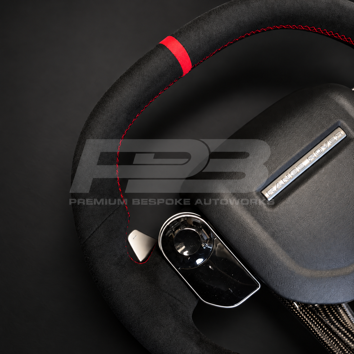 Close up of Range Rover Sport L494 custom steering wheel red 12 o'clock marker on black Alcantara with silver paddle shifter
