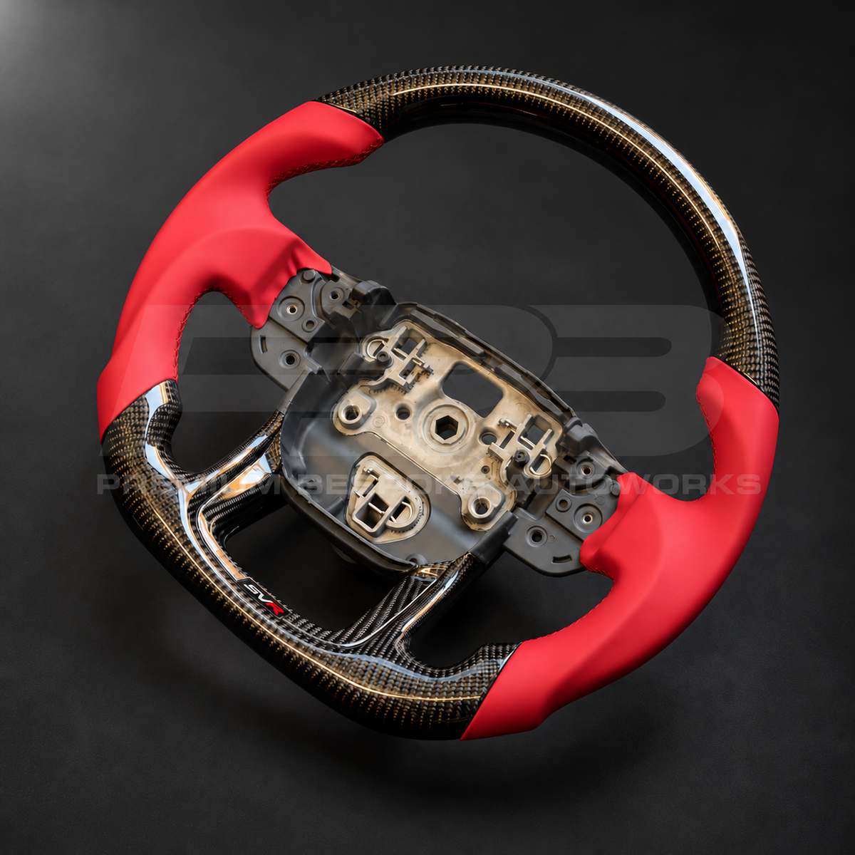 Range Rover Sport L494 SVR custom steering wheel right angle showing flat bottom, gloss carbon fibre top and bottom, SVR red leather grips and stitching, carbon lower trim with SVR badge